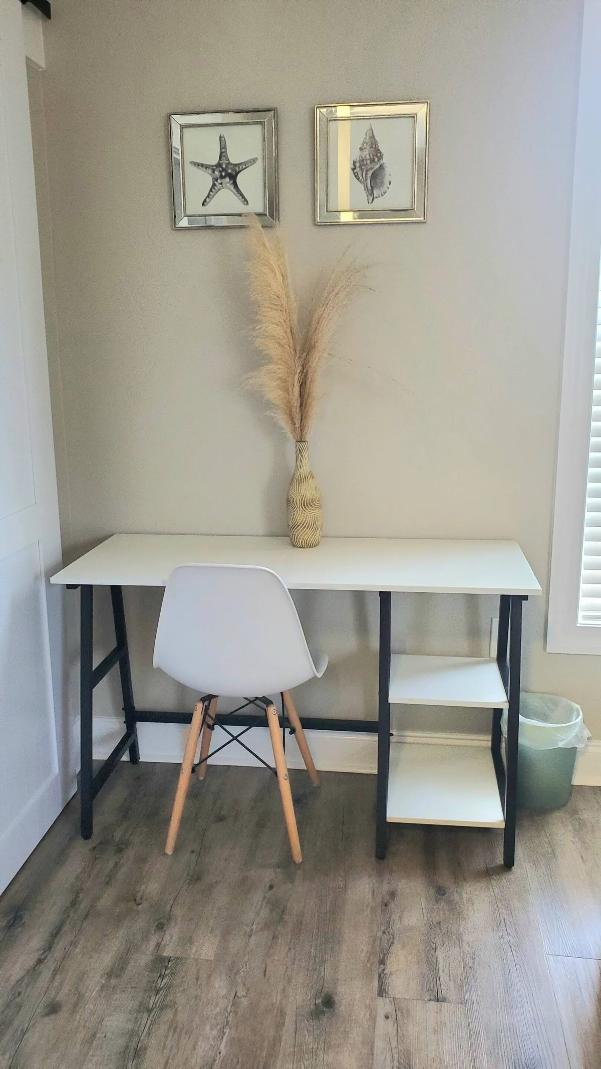 A quiet nook featuring a modern desk, comfortable chair, and tasteful decor like a vase with pampas grass and framed art. The setup is ideal for working, studying, or creative pursuits, emphasizing the studio’s workspace amenities.