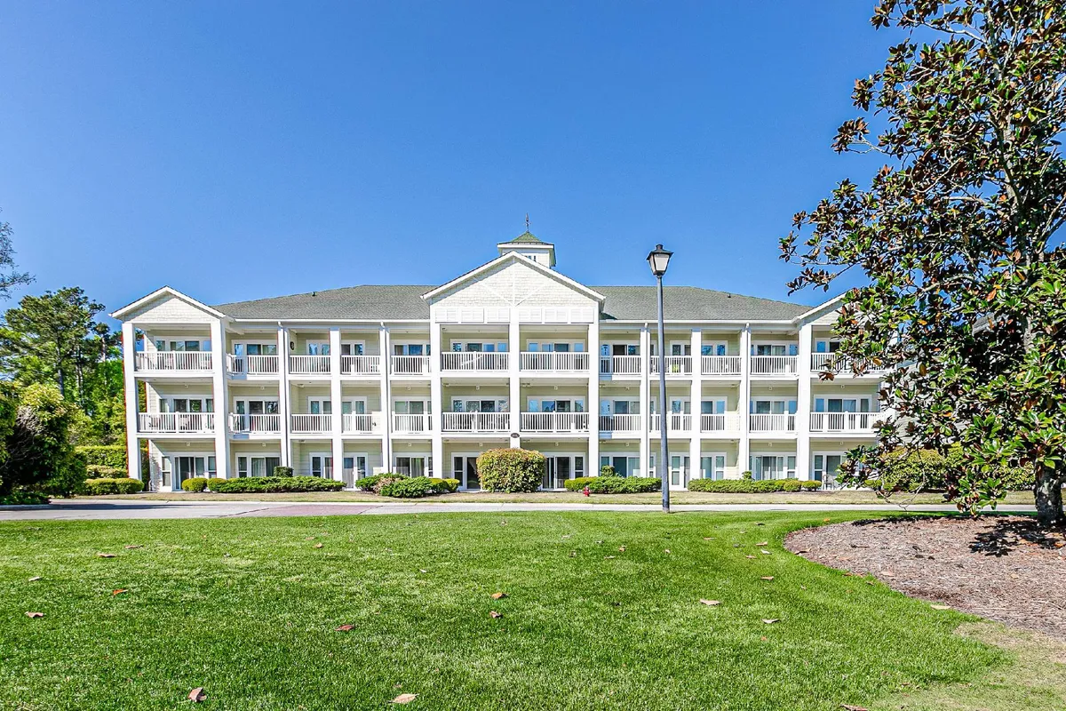 This exterior image highlights the resort-style building with balconies, a landscaped garden, and a welcoming atmosphere. It suggests the comfort and sense of community available within the resort, just steps from the golf action.