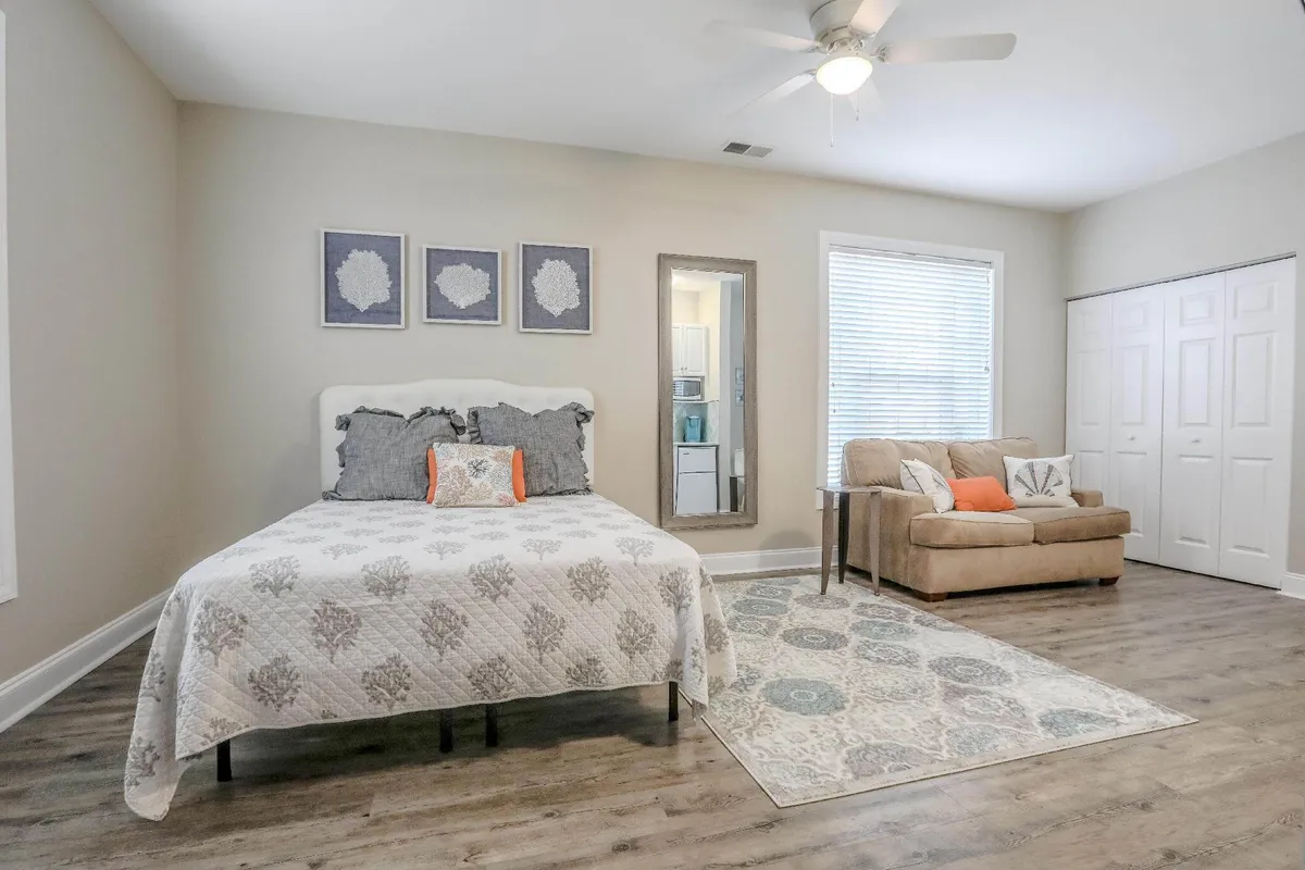 A stylish interior showcasing a bed with decorative pillows, a cozy sofa, and wall art that adds a touch of elegance. This space radiates a sense of calm, perfect for unwinding after a day of culinary adventures or exploring the area.